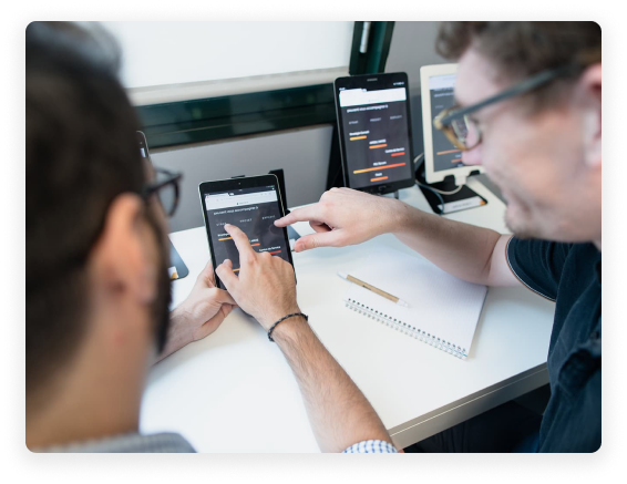 Deux collaborateurs testant une fonction sur une tablette